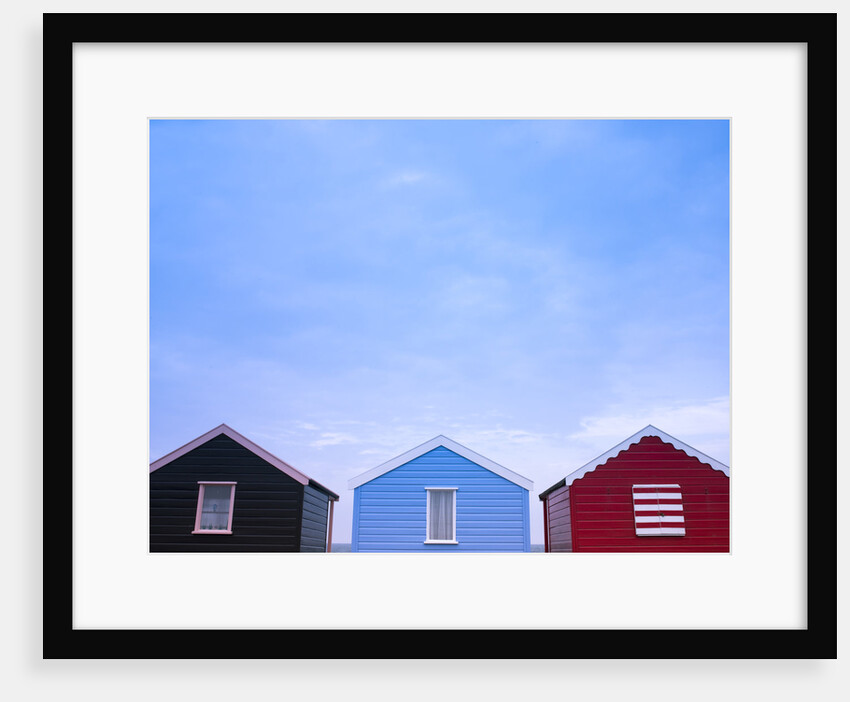 Beach huts in a row against sky by Assaf Frank